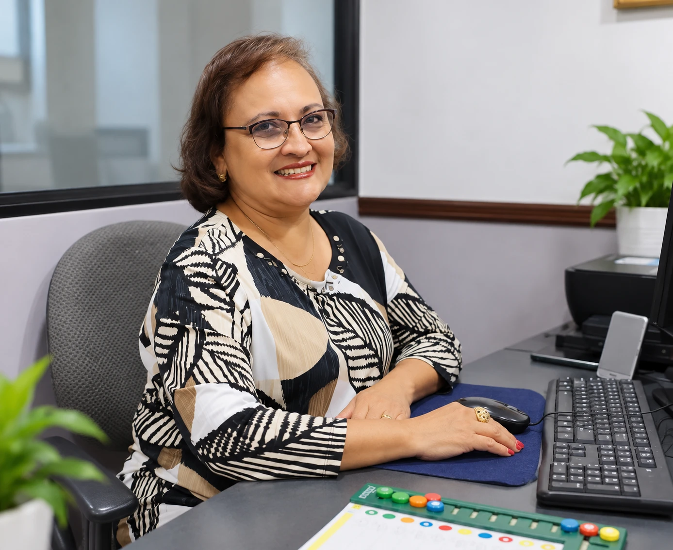 Retrato de la licenciada Alma Cisneros, sonriente, en su escritorio junto a material de terapia de aprendizaje.